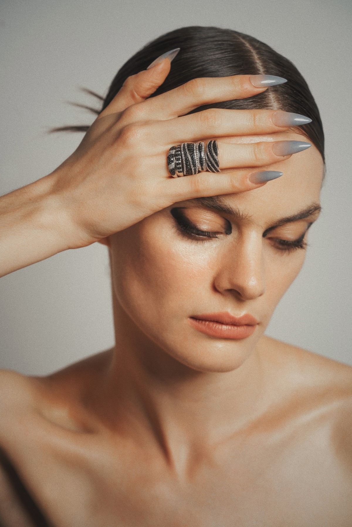 close up de mujer con una mano con cuatro anillos de bizzarro, diamante negro.