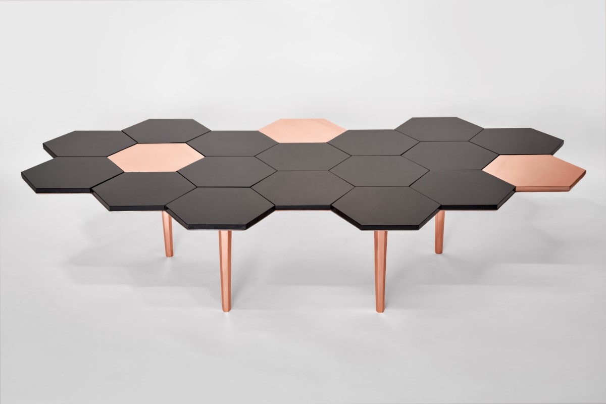 Se aprecia la mesa Honeycomb, creación de Sten Studio, misma que tiene una forma de panal de abeja en colores negro y dorado.